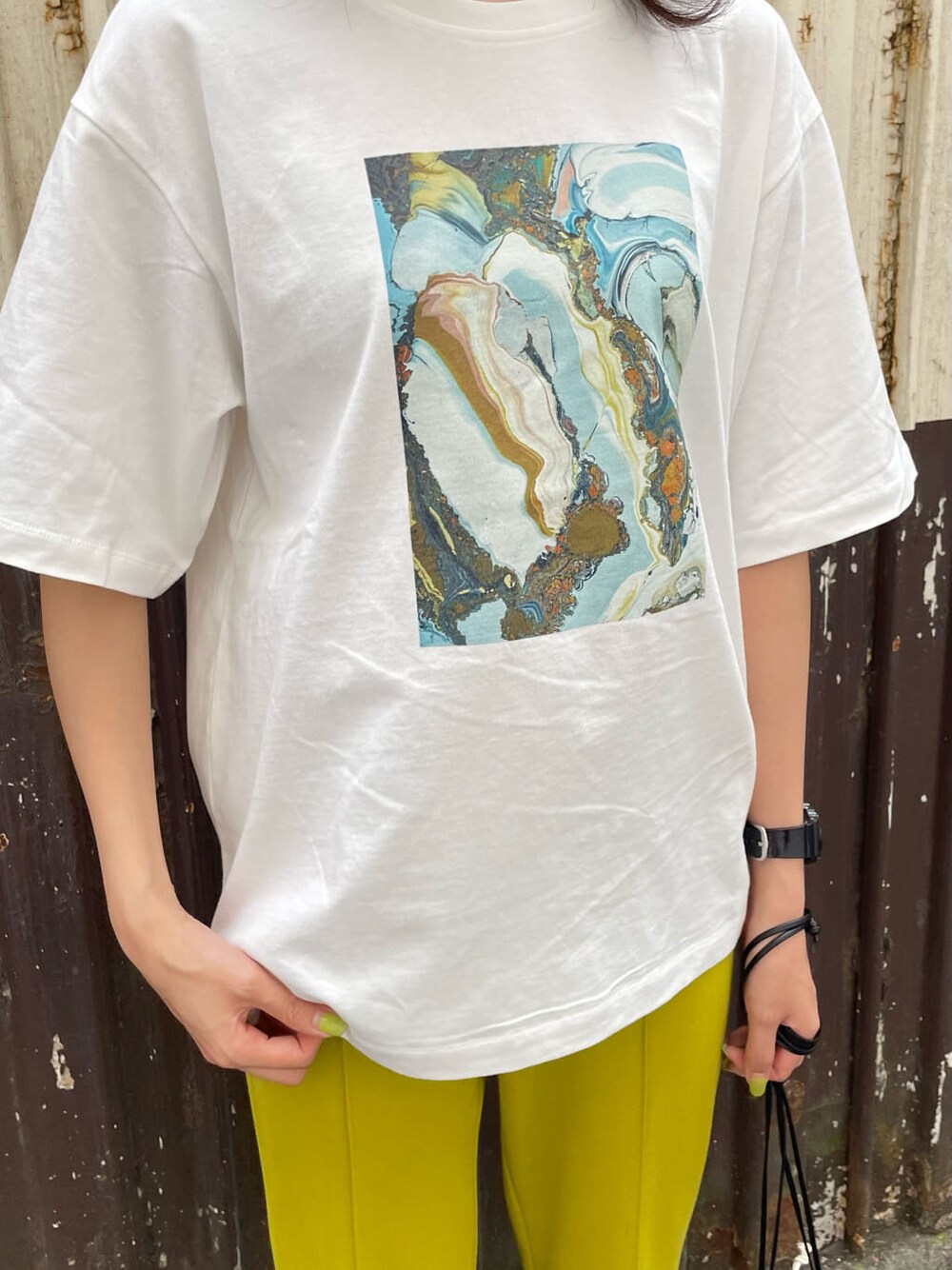 ブラック系のサンダル、ブラック系のハンドバッグ、ホワイト系のTシャツ/カットソーを着用したレディースの春コーディネートの5枚目の写真