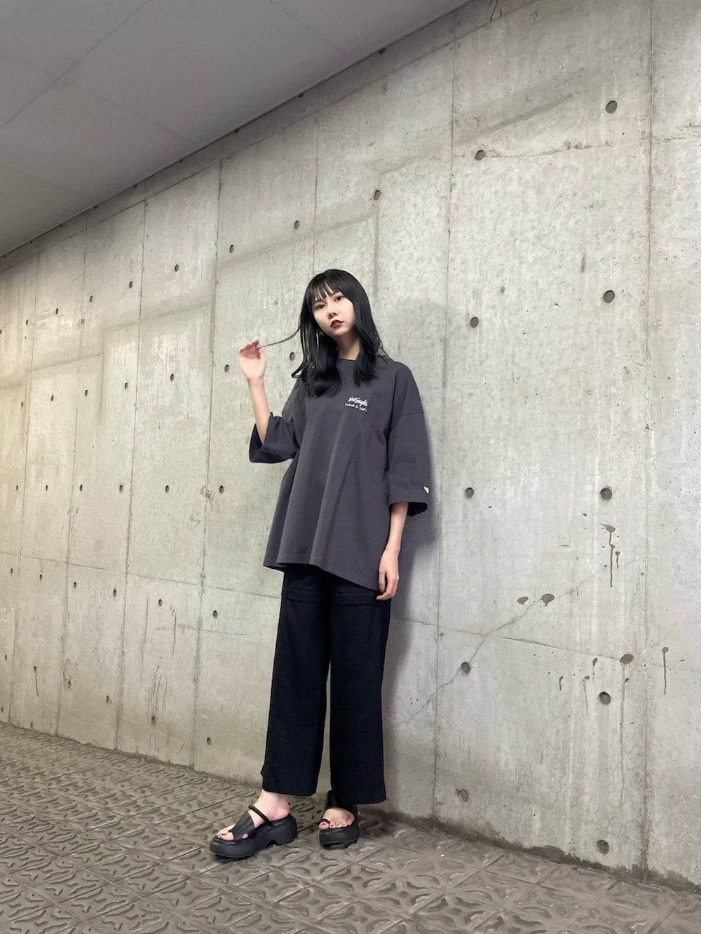 グレー系のTシャツ/カットソー、ブラック系のサンダルを着用したレディースの春コーディネートの2枚目の写真