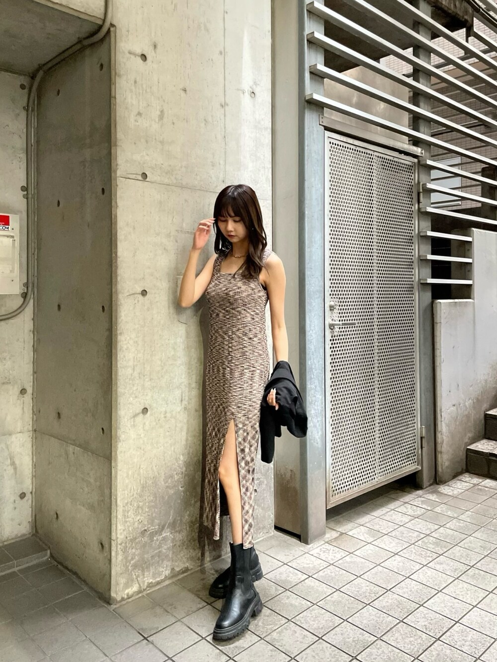 ブラック系のテーラードジャケット、ブラウン系のワンピースを着用したレディースの春コーディネートの2枚目の写真