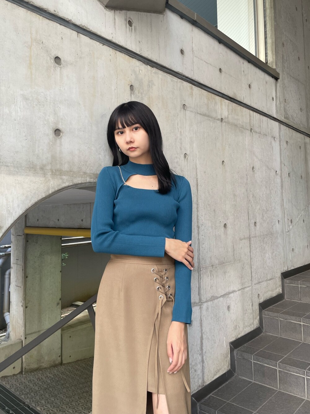 ブルー系のニット/セーター、ベージュ系のスカート、ブラック系のブーツを着用したレディースの夏コーディネートの4枚目の写真