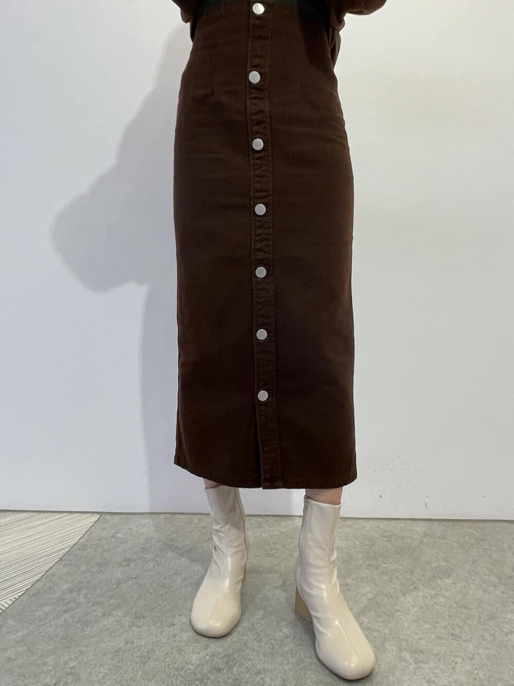 ブラウン系のブルゾン、ブラウン系のスカート、ホワイト系のブーツを着用したレディースの秋コーディネートの5枚目の写真