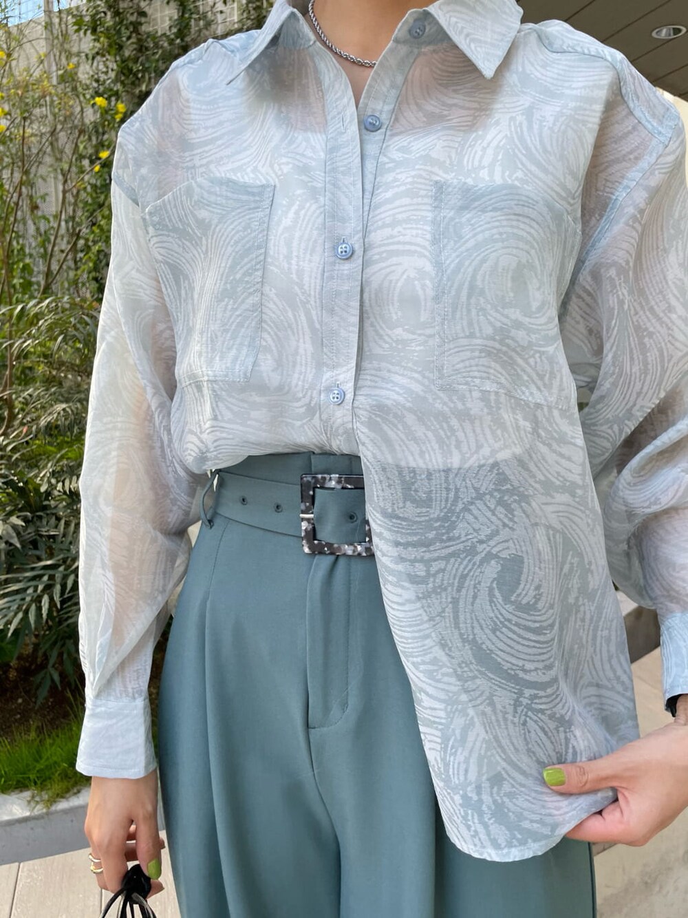 ホワイト系のタンクトップ、ブラック系のハンドバッグ、ブルー系のシャツ/ブラウスを着用したレディースの春コーディネートの4枚目の写真