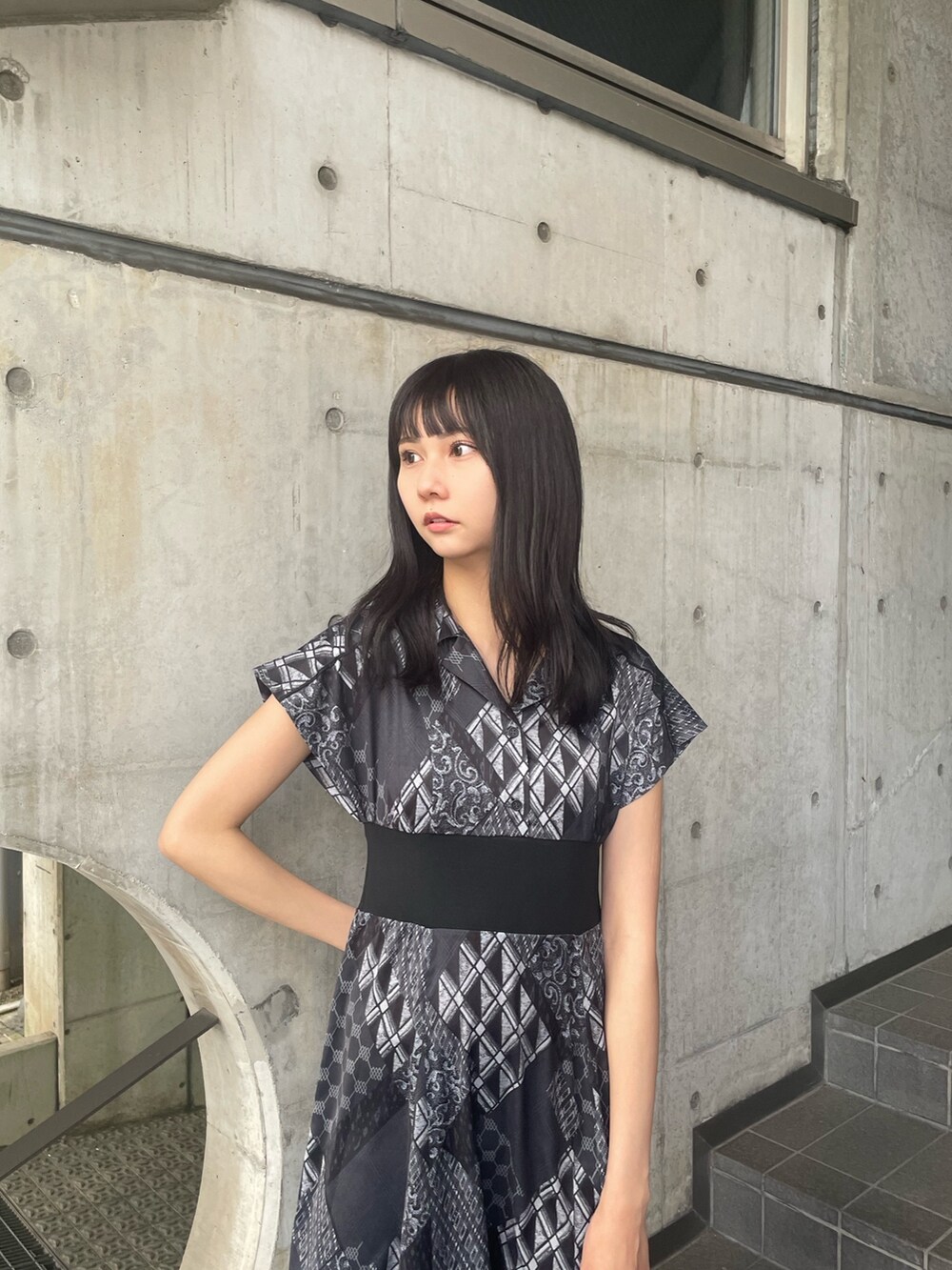 ブラック系のワンピース、ブラック系のハンドバッグ、ブラック系のサンダルを着用したレディースの春コーディネートの3枚目の写真