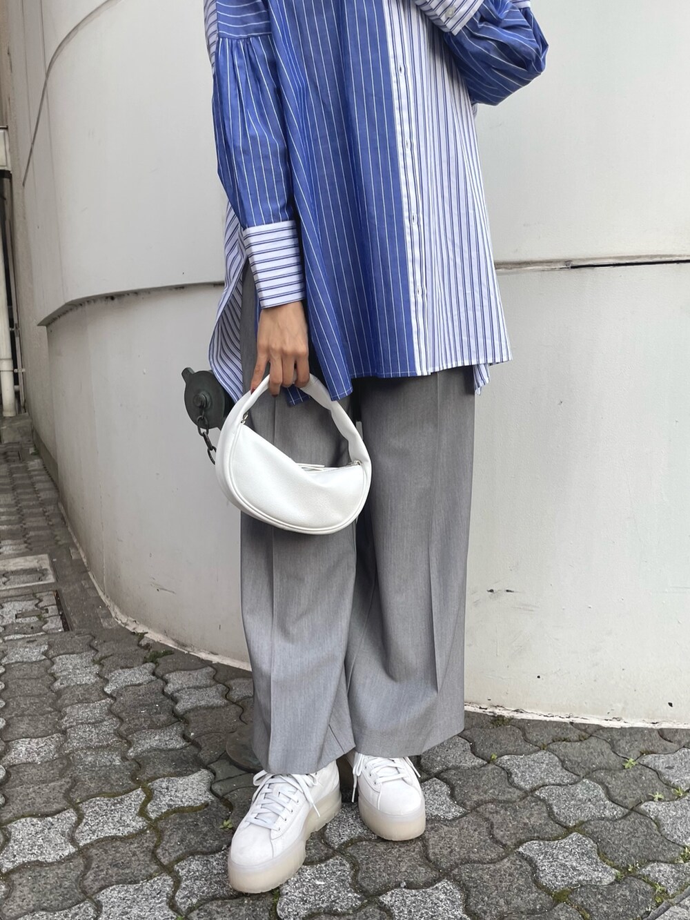 ブルー系のシャツ/ブラウス、ホワイト系のハンドバッグ、グレー系のスラックスを着用したレディースの冬コーディネートの7枚目の写真