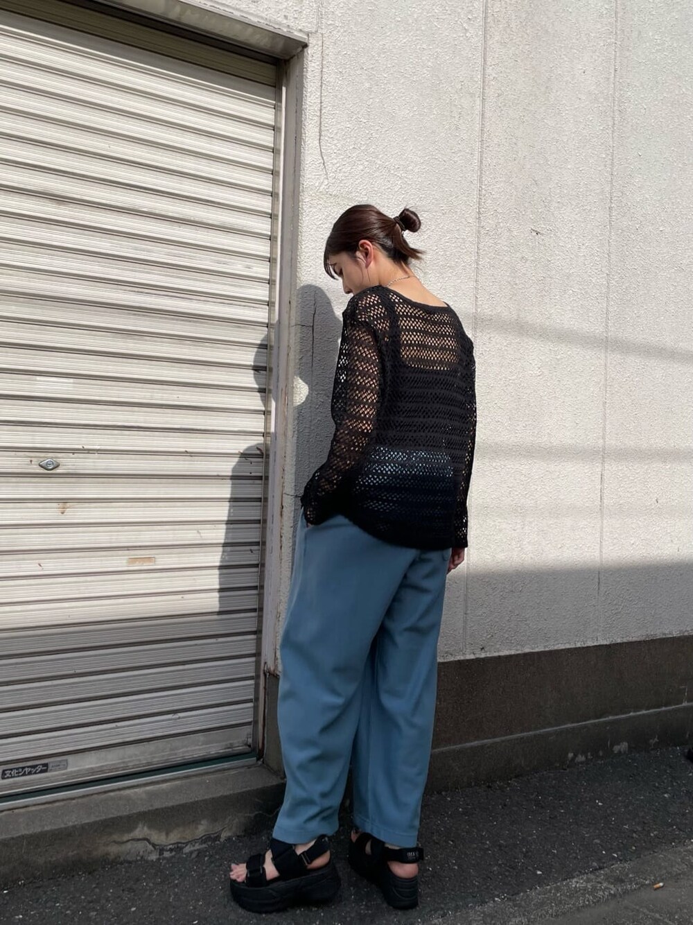 ブルー系のスウェットパンツ、ホワイト系のサンダル、ブラック系のTシャツ/カットソーを着用したレディースの春コーディネートの2枚目の写真