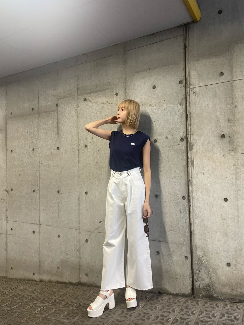 ブルー系のタンクトップ、ホワイト系のデニムパンツを着用したレディースの冬コーディネートの2枚目の写真