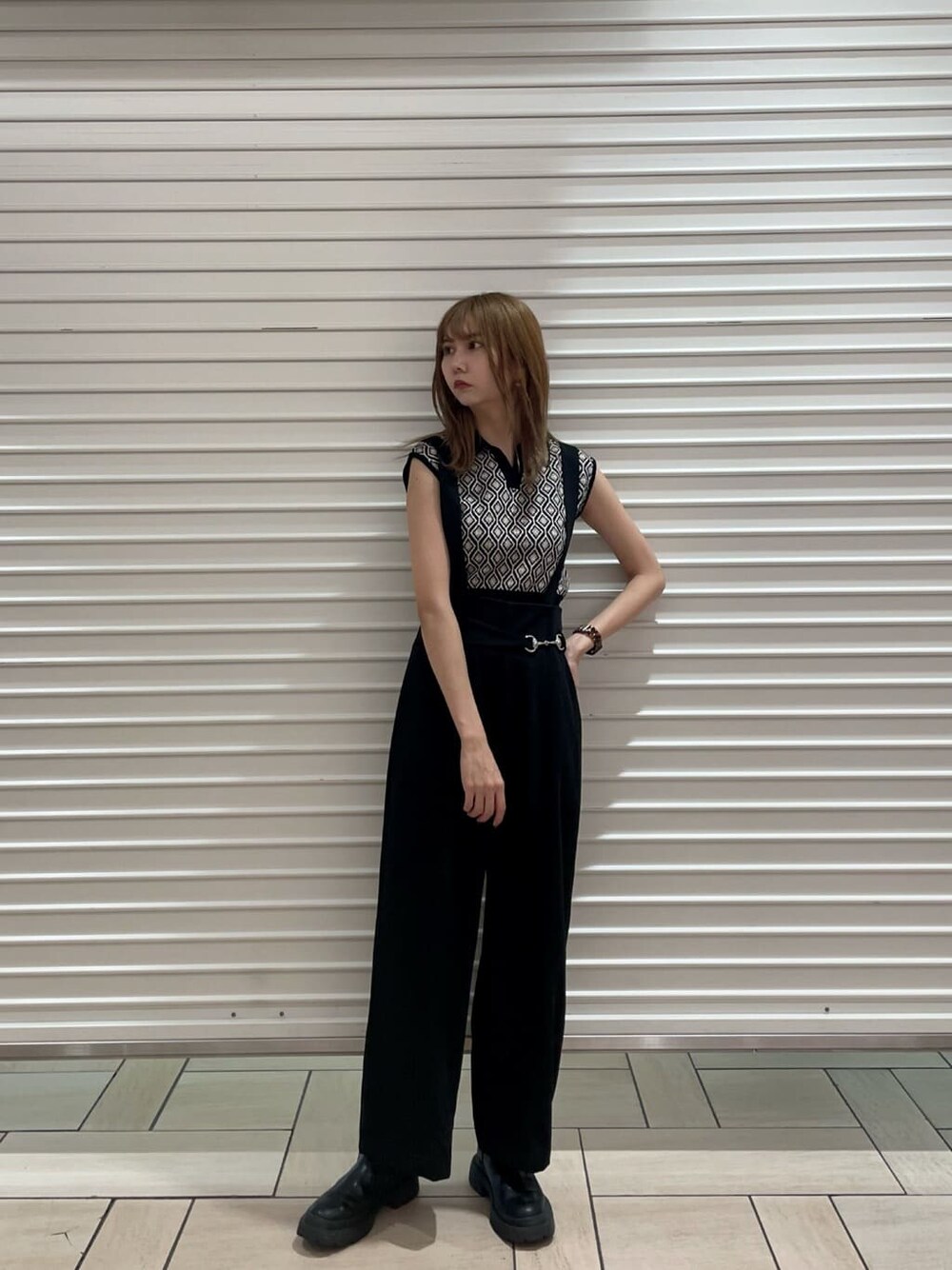 ブラック系のスラックス、ブラック系のニット/セーター、グリーン系のステンカラーコートを着用したレディースの夏コーディネートの5枚目の写真