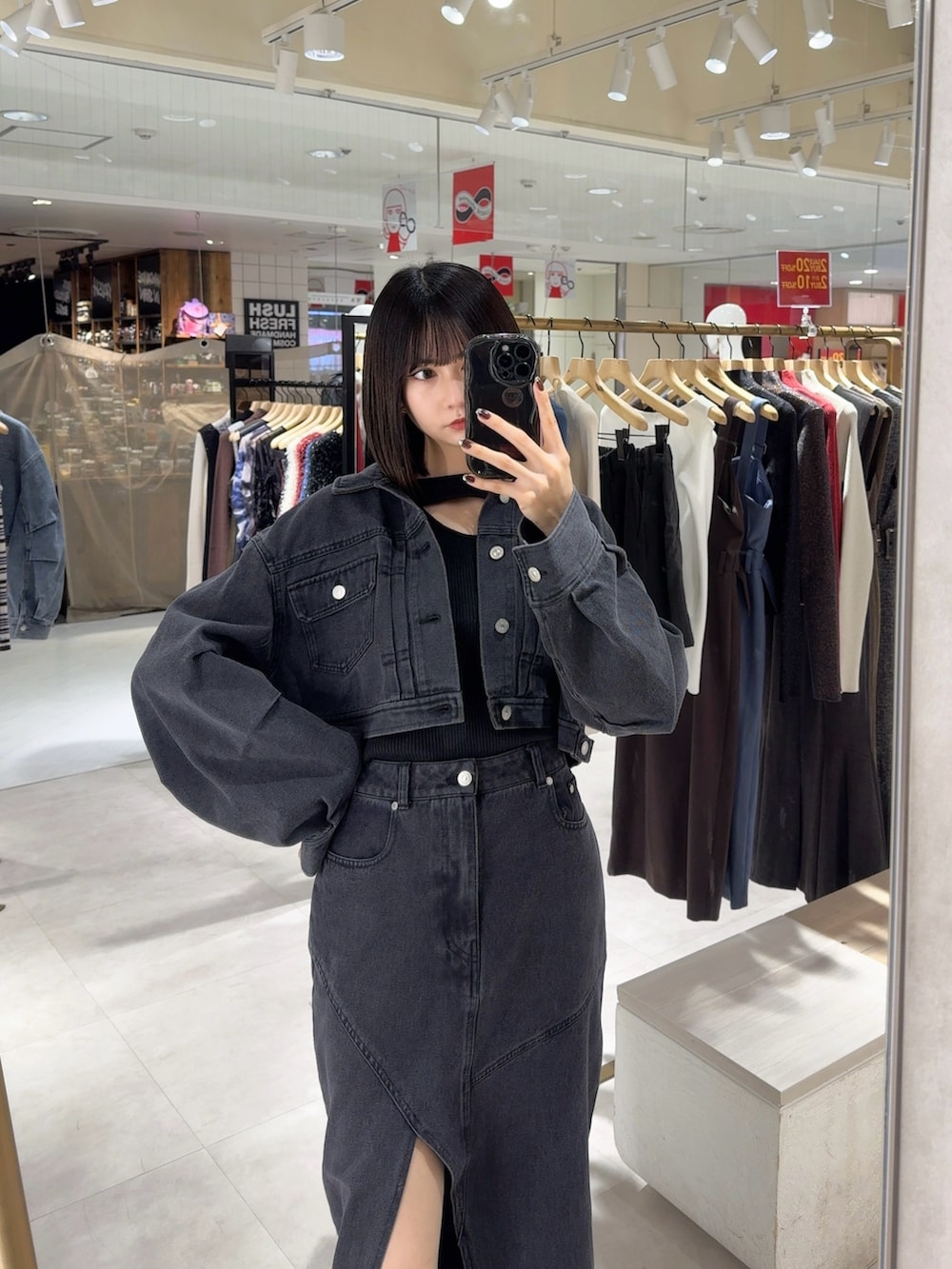 ブラック系のデニムスカート、ブラック系のブーツ、ブラック系のデニムジャケットを着用したレディースの冬コーディネートの2枚目の写真