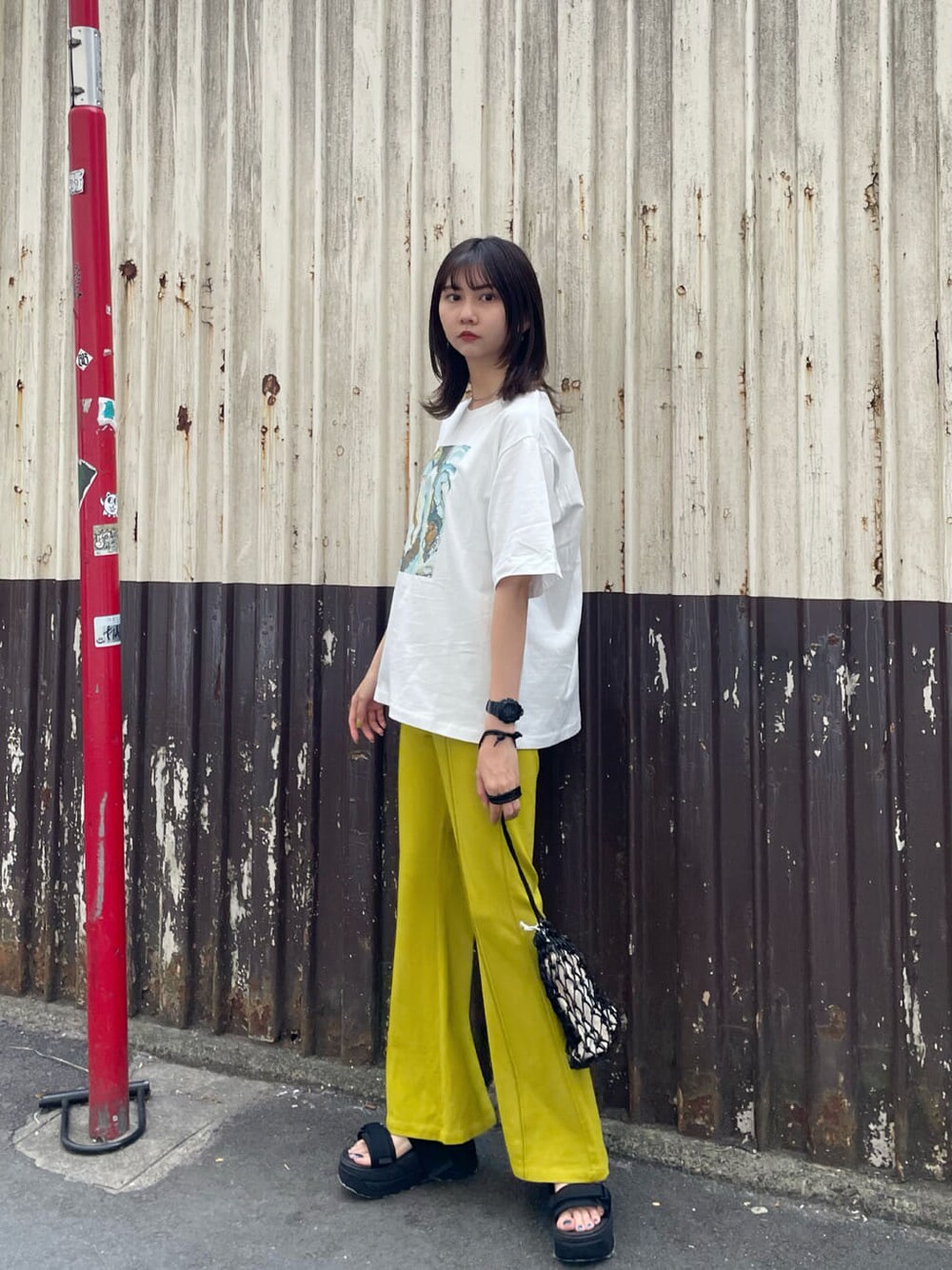 ブラック系のサンダル、ブラック系のハンドバッグ、ホワイト系のTシャツ/カットソーを着用したレディースの春コーディネートの2枚目の写真