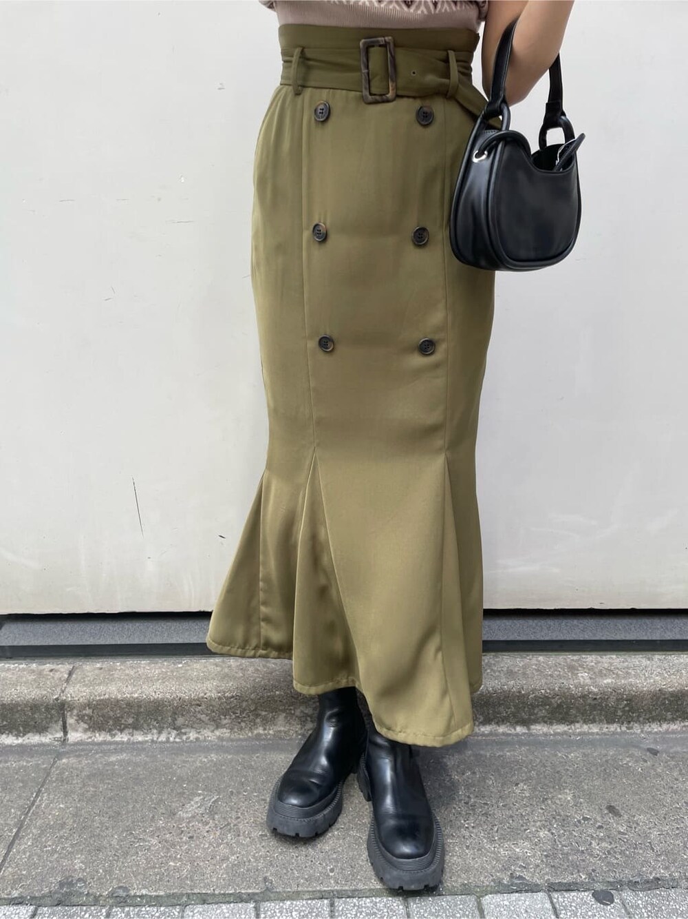 ベージュ系のスカート、ブラック系のハンドバッグ、ベージュ系のニット/セーターを着用したレディースの夏コーディネートの5枚目の写真