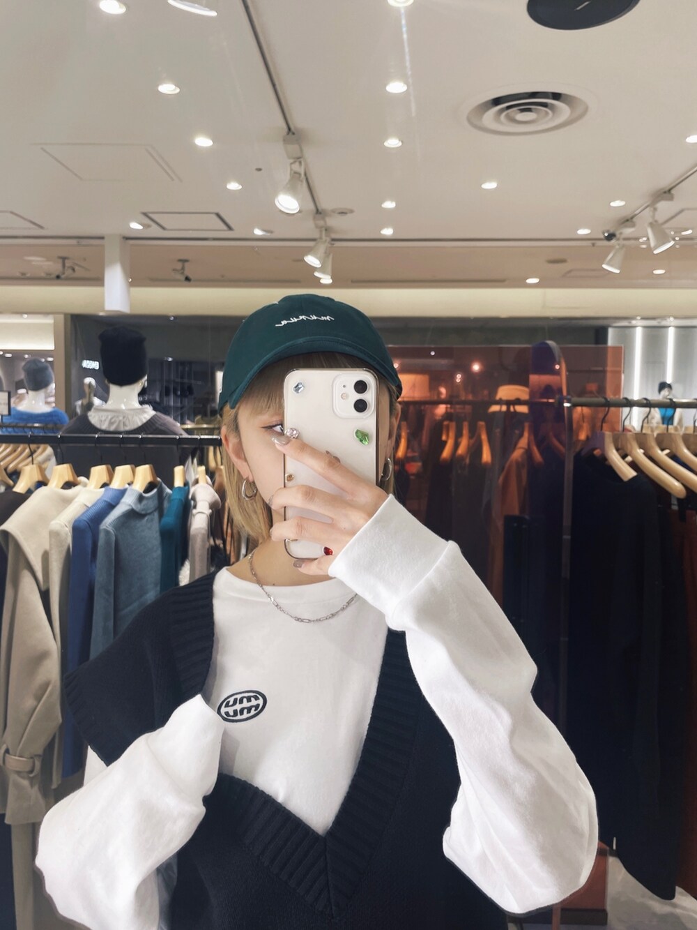 ホワイト系のTシャツ/カットソー、ブラック系のベスト、グリーン系のキャップを着用したレディースの冬コーディネートの4枚目の写真