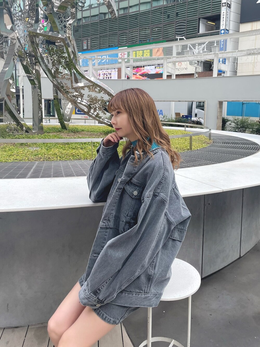 グレー系のデニムジャケット、グレー系のスカート、ブラック系のブーツを着用したレディースの冬コーディネートの4枚目の写真