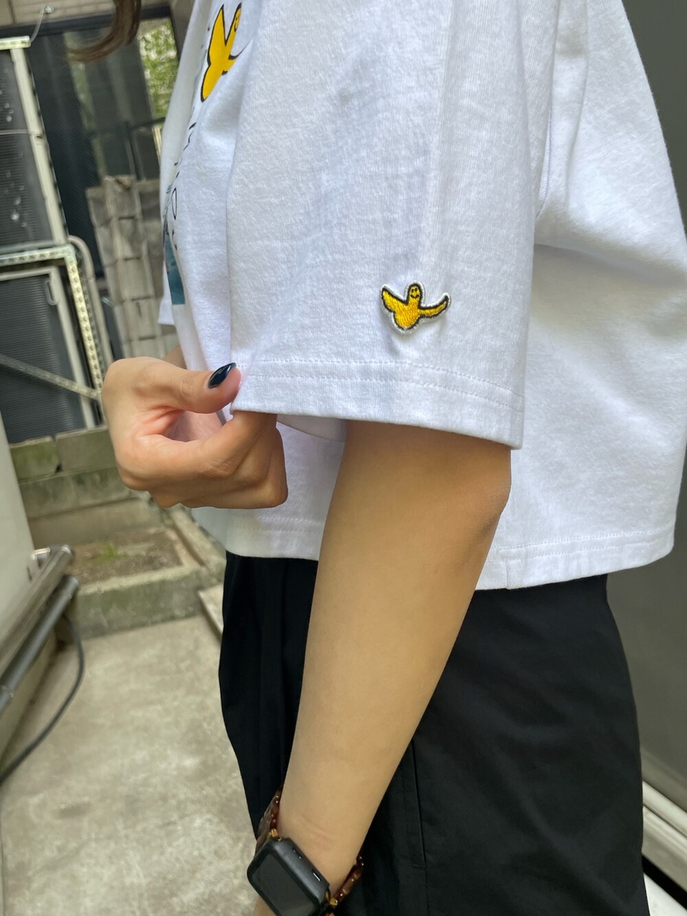 ホワイト系のTシャツ/カットソー、ブラック系のカーゴパンツ、ブラック系のサンダルを着用したレディースの春コーディネートの6枚目の写真