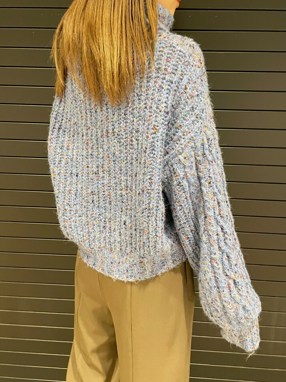 ブルー系のニット/セーター、ブラック系のハンドバッグ、ブラック系のブーツを着用したレディースの冬コーディネートの7枚目の写真