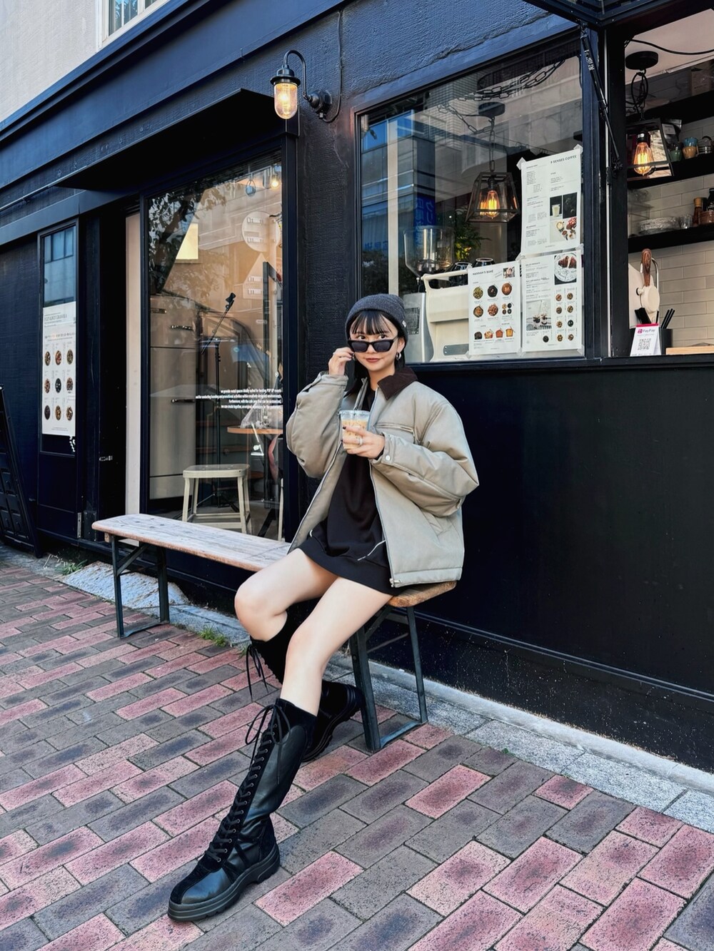 グリーン系のブルゾン、ブラック系のブーツ、ブラック系のスウェットを着用したレディースの秋コーディネートの3枚目の写真