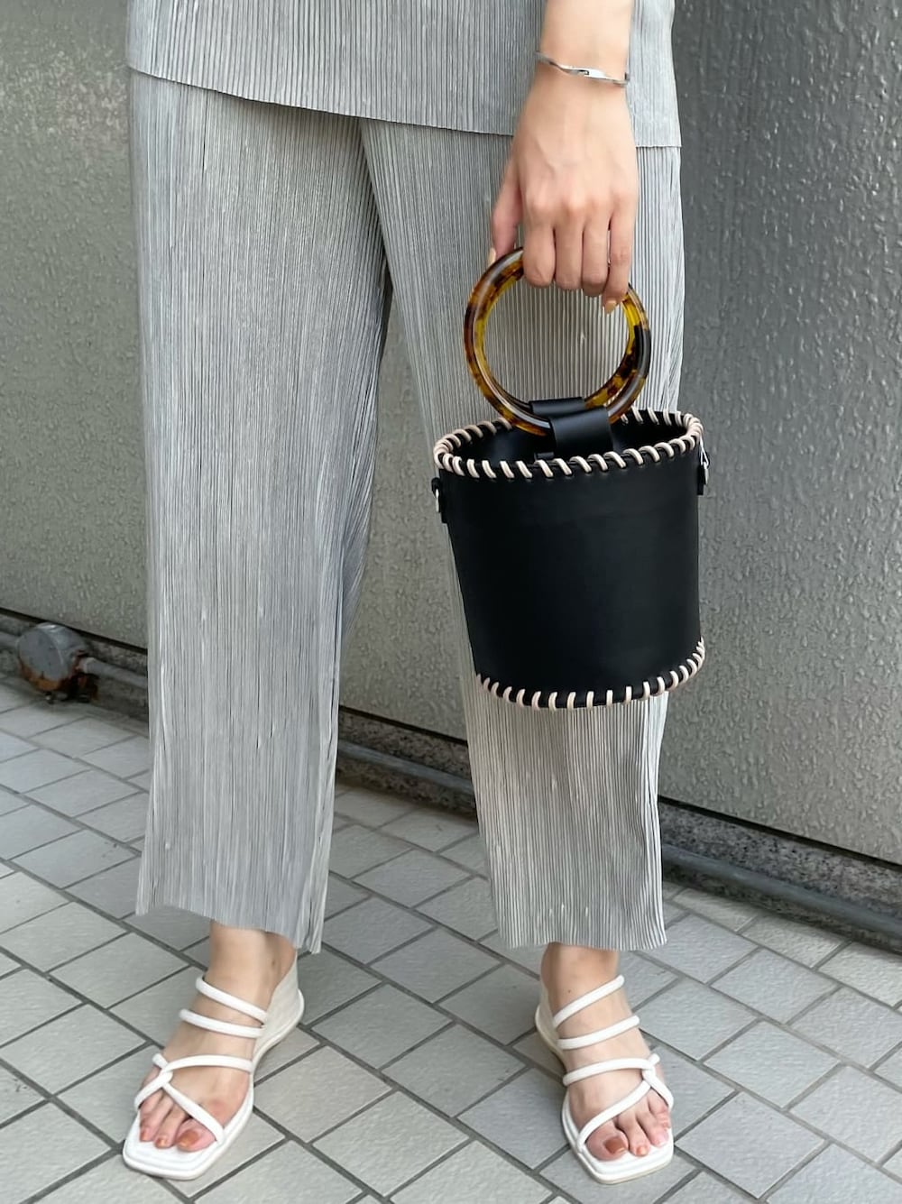 グレー系のスウェットパンツ、ブラック系のハンドバッグ、ホワイト系のサンダルを着用したレディースの夏コーディネートの6枚目の写真