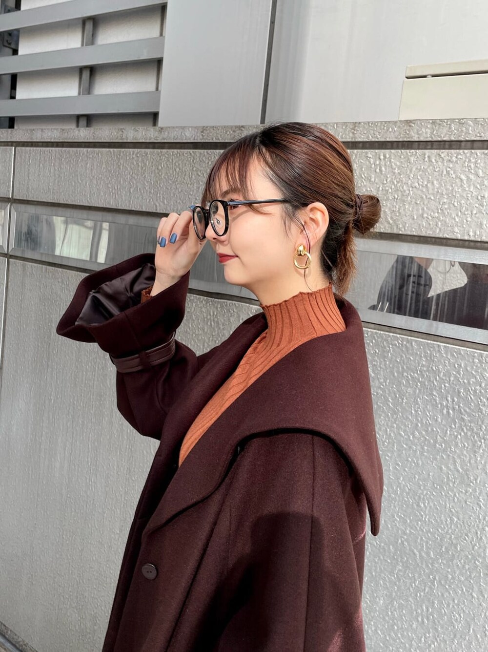 ブラック系のブーツ、ブラウン系のチェスターコート、ブラック系のデニムパンツを着用したレディースの冬コーディネートの5枚目の写真