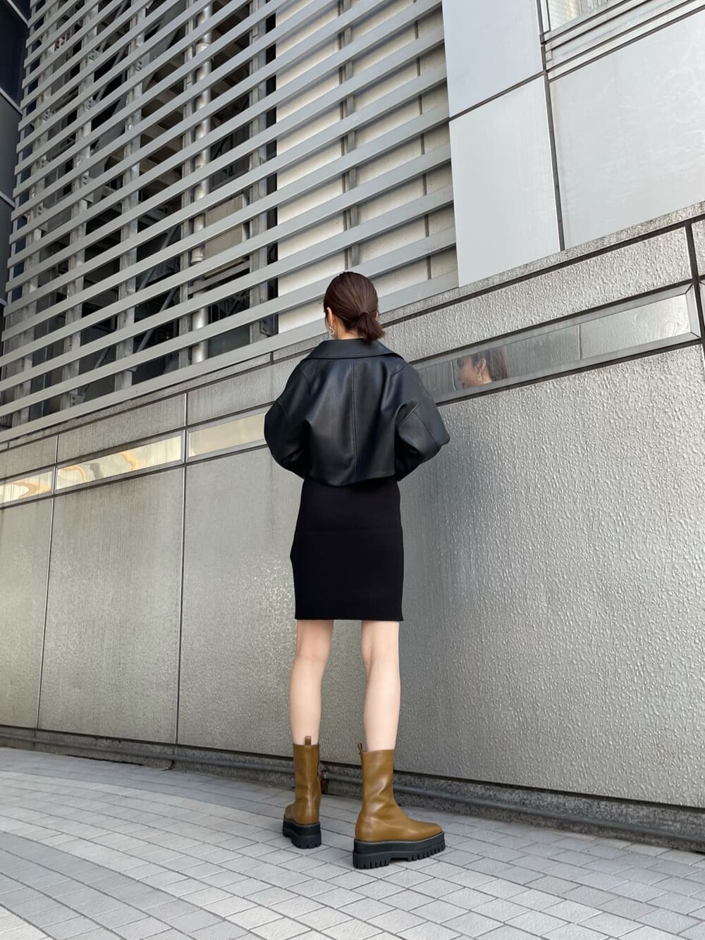 ブラック系のワンピース、ブラック系のライダースジャケット、ブラウン系のブーツを着用したレディースの秋コーディネートの4枚目の写真