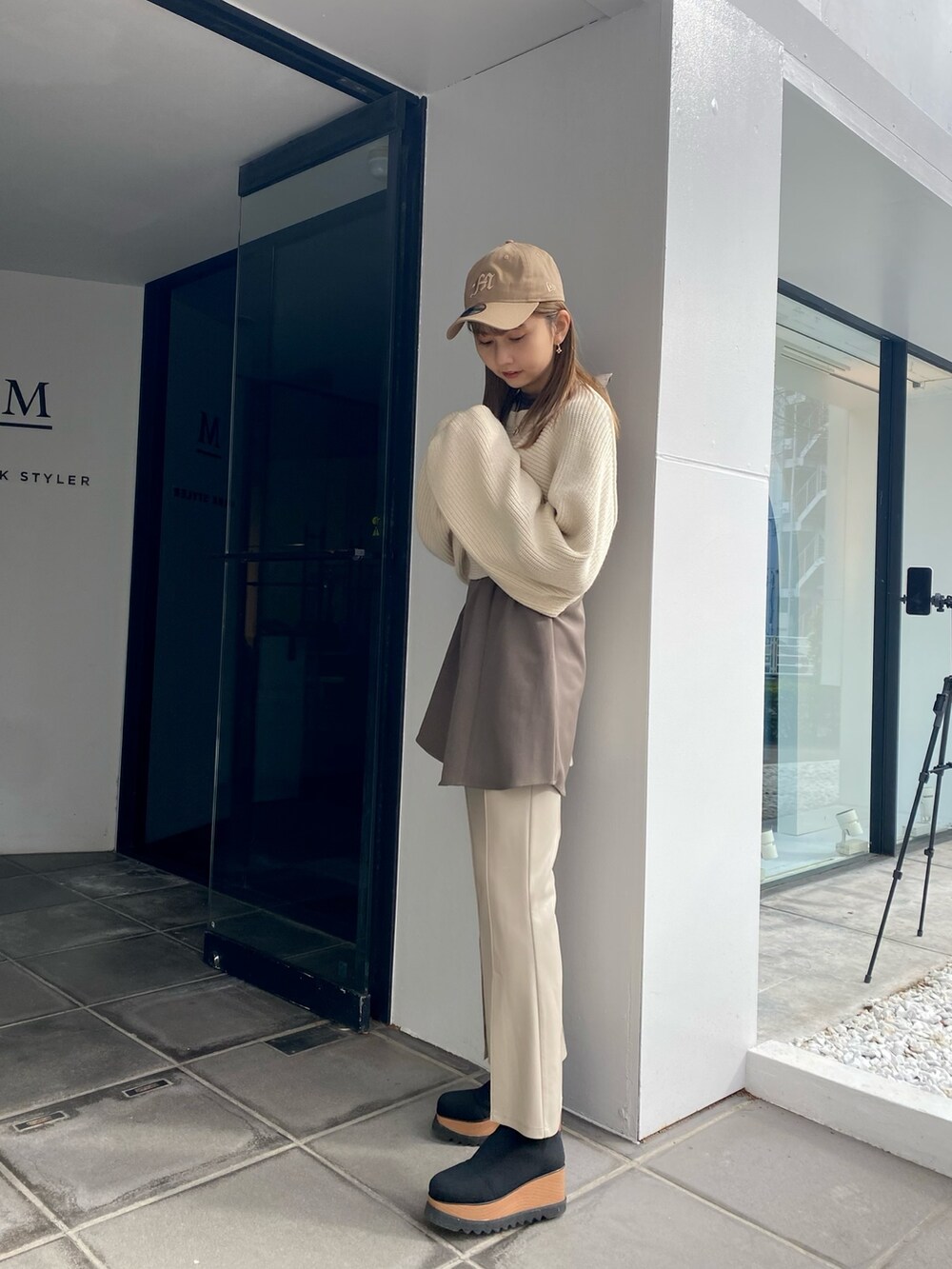 ホワイト系のワンピース、ホワイト系のスラックス、ブラック系のブーツを着用したレディースの冬コーディネートの3枚目の写真