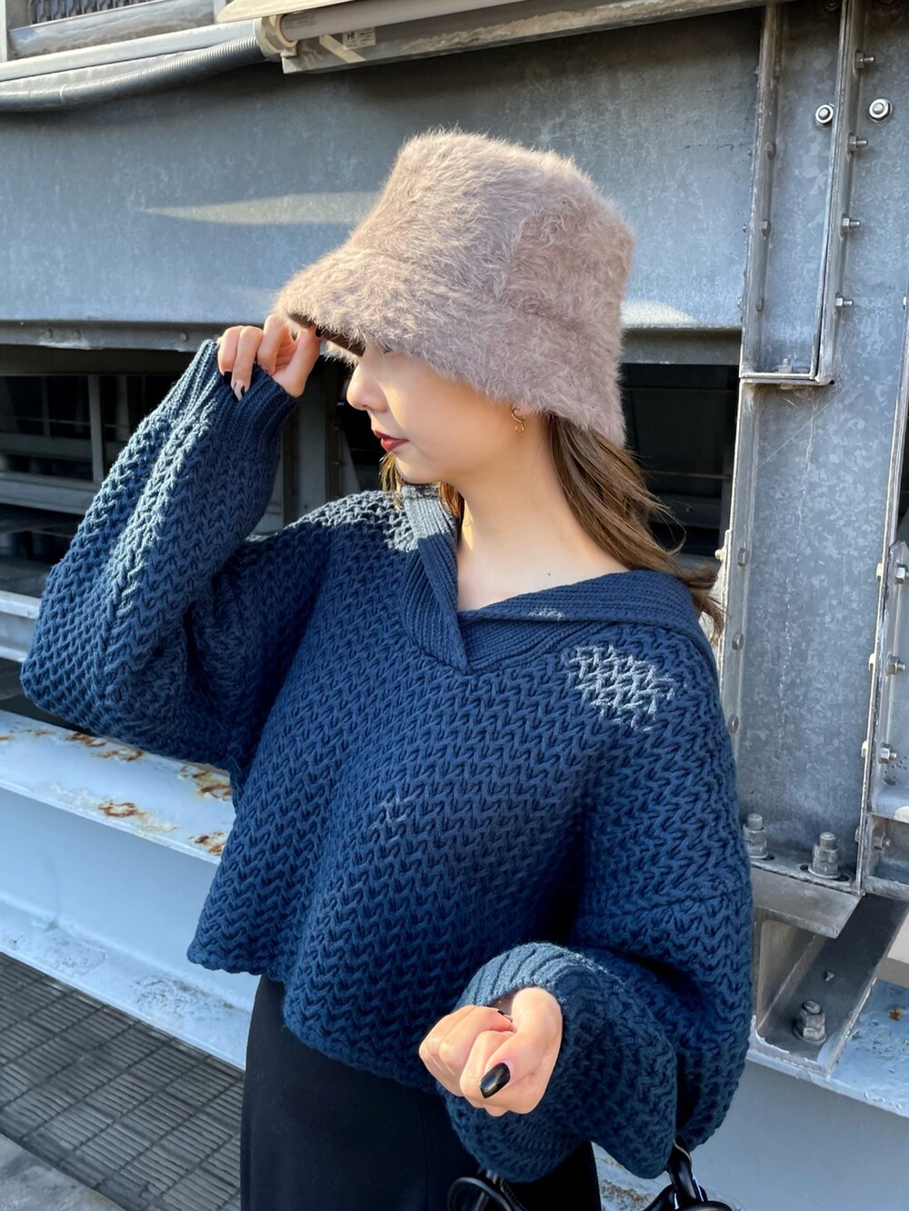 ブルー系のニット/セーター、ブラック系のハンドバッグ、ブラック系のスカートを着用したレディースの冬コーディネートの4枚目の写真