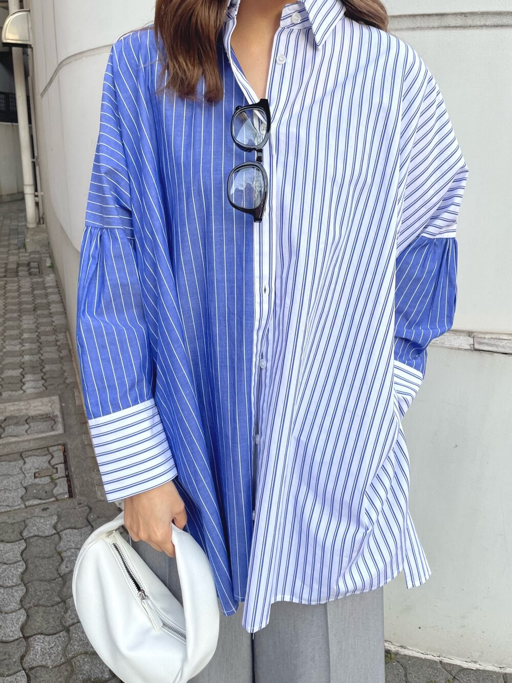 ブルー系のシャツ/ブラウス、ホワイト系のハンドバッグ、グレー系のスラックスを着用したレディースの冬コーディネートの5枚目の写真