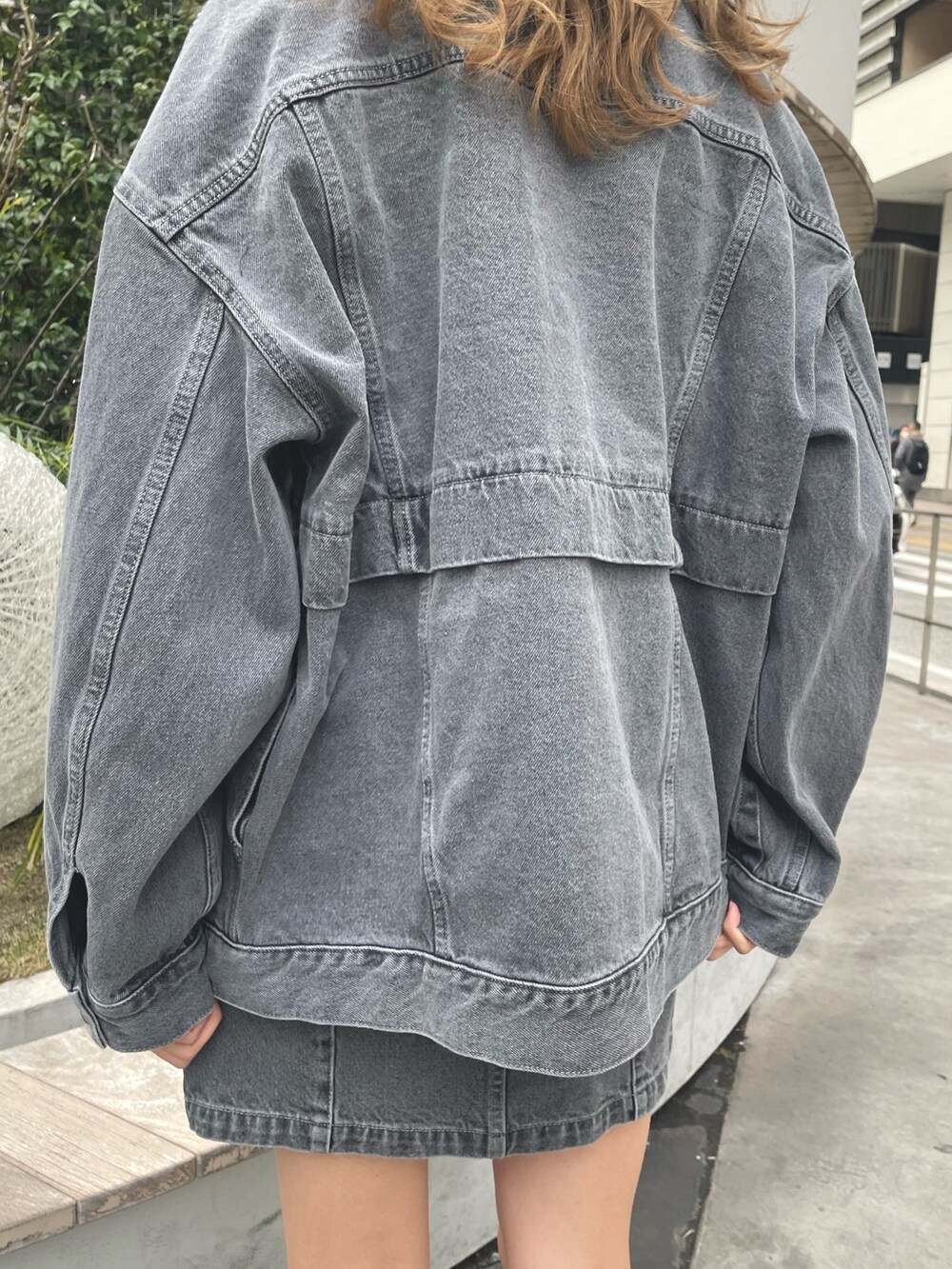 グレー系のデニムジャケット、グレー系のスカート、ブラック系のブーツを着用したレディースの冬コーディネートの10枚目の写真