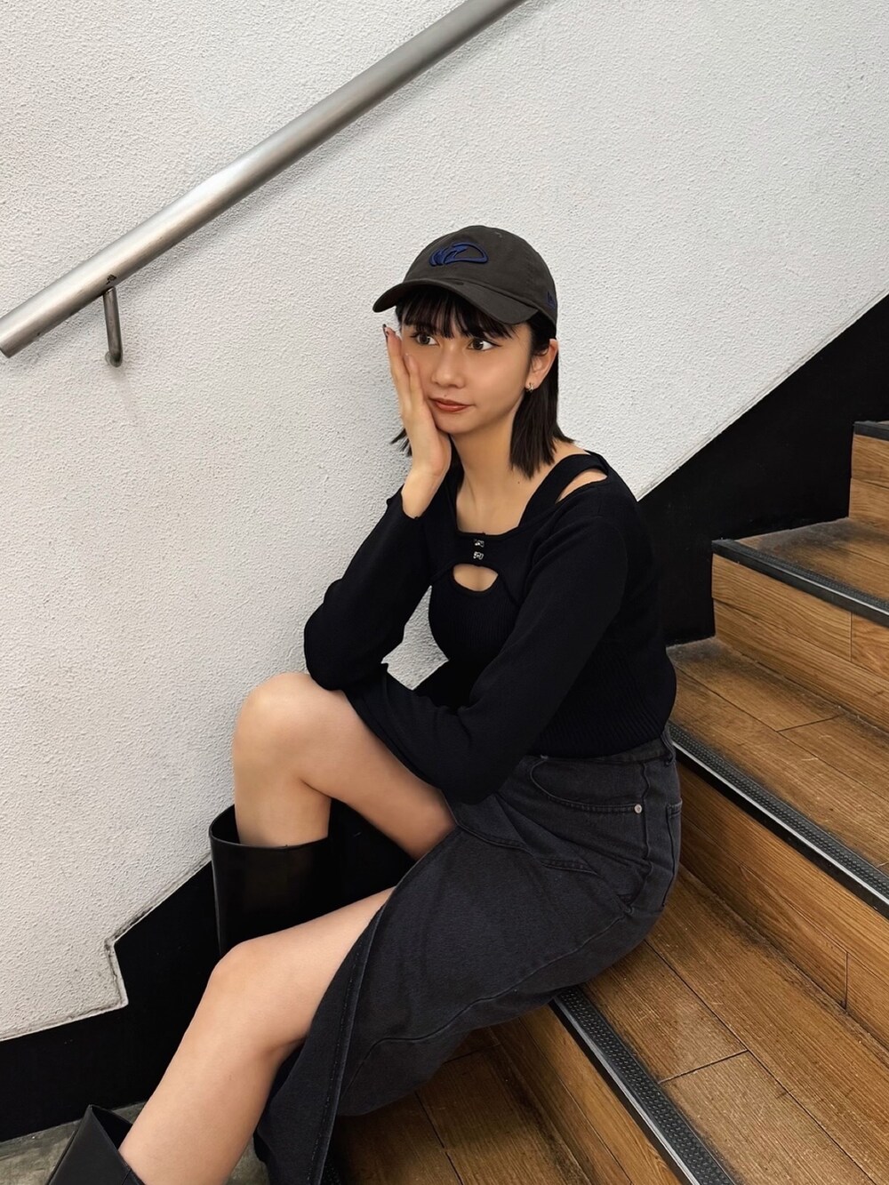 ブラック系のニット/セーター、ブラウン系のキャップを着用したレディースの冬コーディネートの2枚目の写真