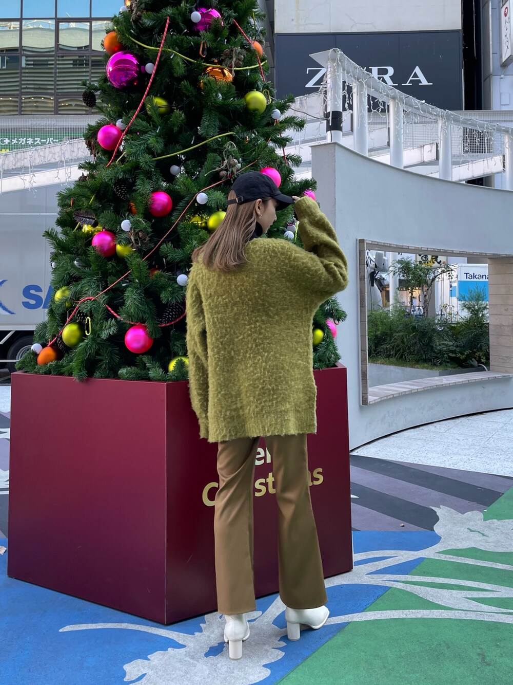 グリーン系のカーディガン/ボレロ、ブラック系のニット/セーター、ブラウン系のスウェットパンツを着用したレディースの冬コーディネートの3枚目の写真