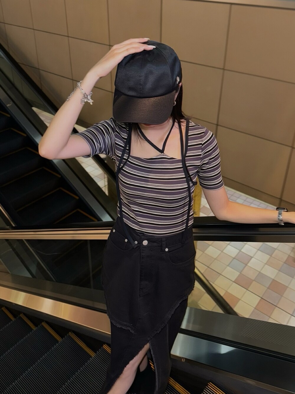 その他のTシャツ/カットソー、ブラック系のデニムスカート、ブラック系のキャップを着用したレディースの夏コーディネートの3枚目の写真
