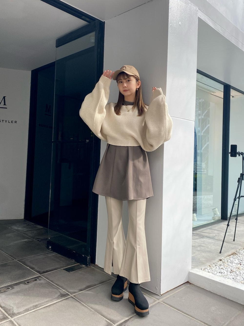 ホワイト系のワンピース、ホワイト系のスラックス、ブラック系のブーツを着用したレディースの冬コーディネートの2枚目の写真