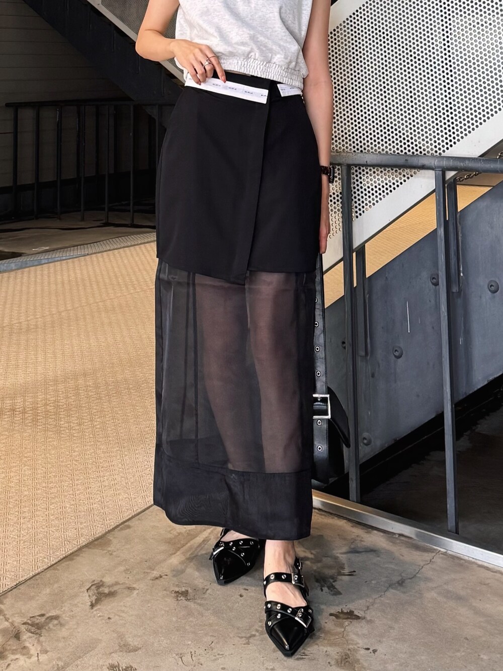 ホワイト系のTシャツ/カットソー、ブラック系のスカート、ブラック系のパンプスを着用したレディースの夏コーディネートの2枚目の写真