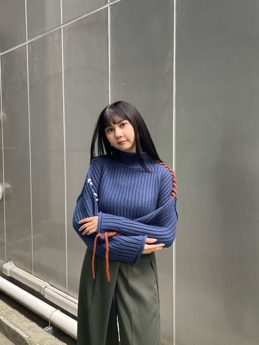 ブルー系のニット/セーター、グリーン系のスラックス、ブラック系のブーツを着用したレディースの夏コーディネートの4枚目の写真