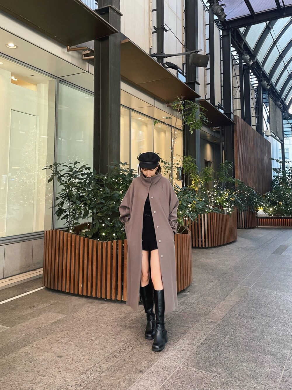 ブラウン系のステンカラーコートを着用したレディースの冬コーディネートの3枚目の写真