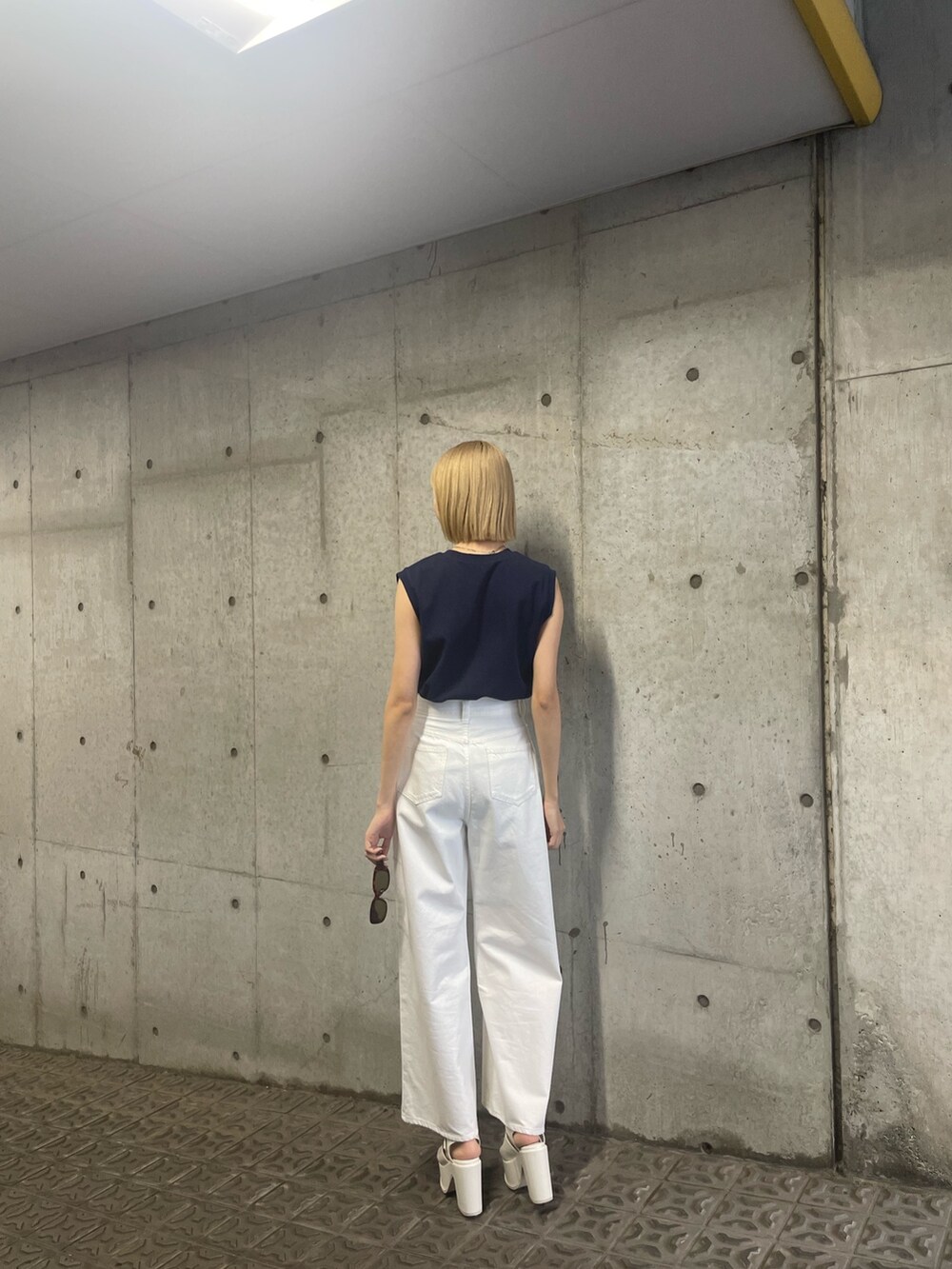 ブルー系のタンクトップ、ホワイト系のデニムパンツを着用したレディースの冬コーディネートの5枚目の写真