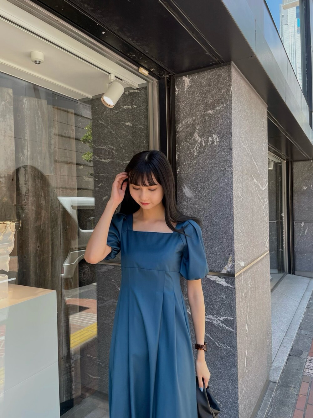 ブラック系のサンダル、ブルー系のワンピースを着用したレディースの夏コーディネートの3枚目の写真