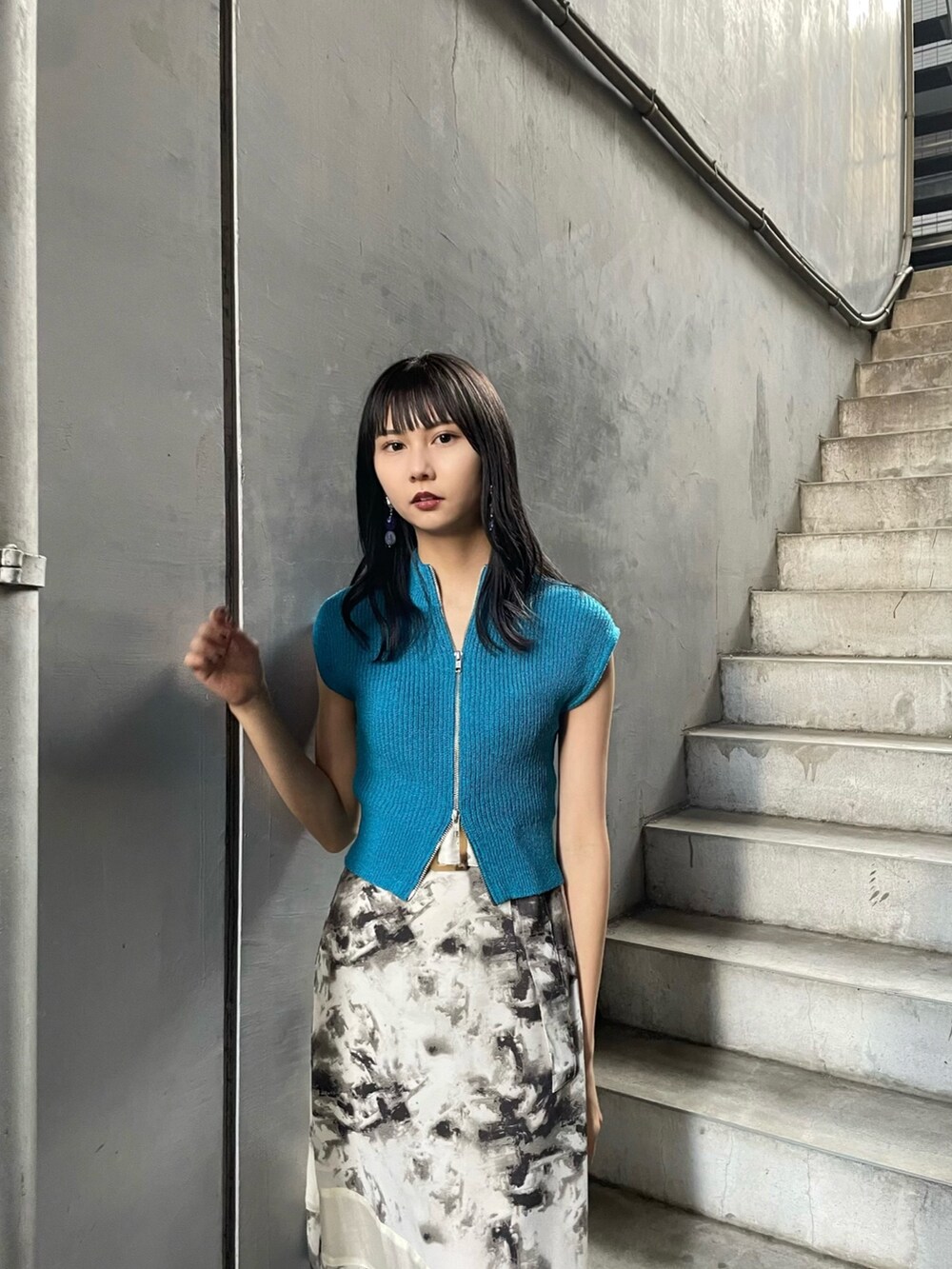 ブルー系のニット/セーター、その他のスカート、ブラック系のサンダルを着用したレディースの春コーディネートの4枚目の写真