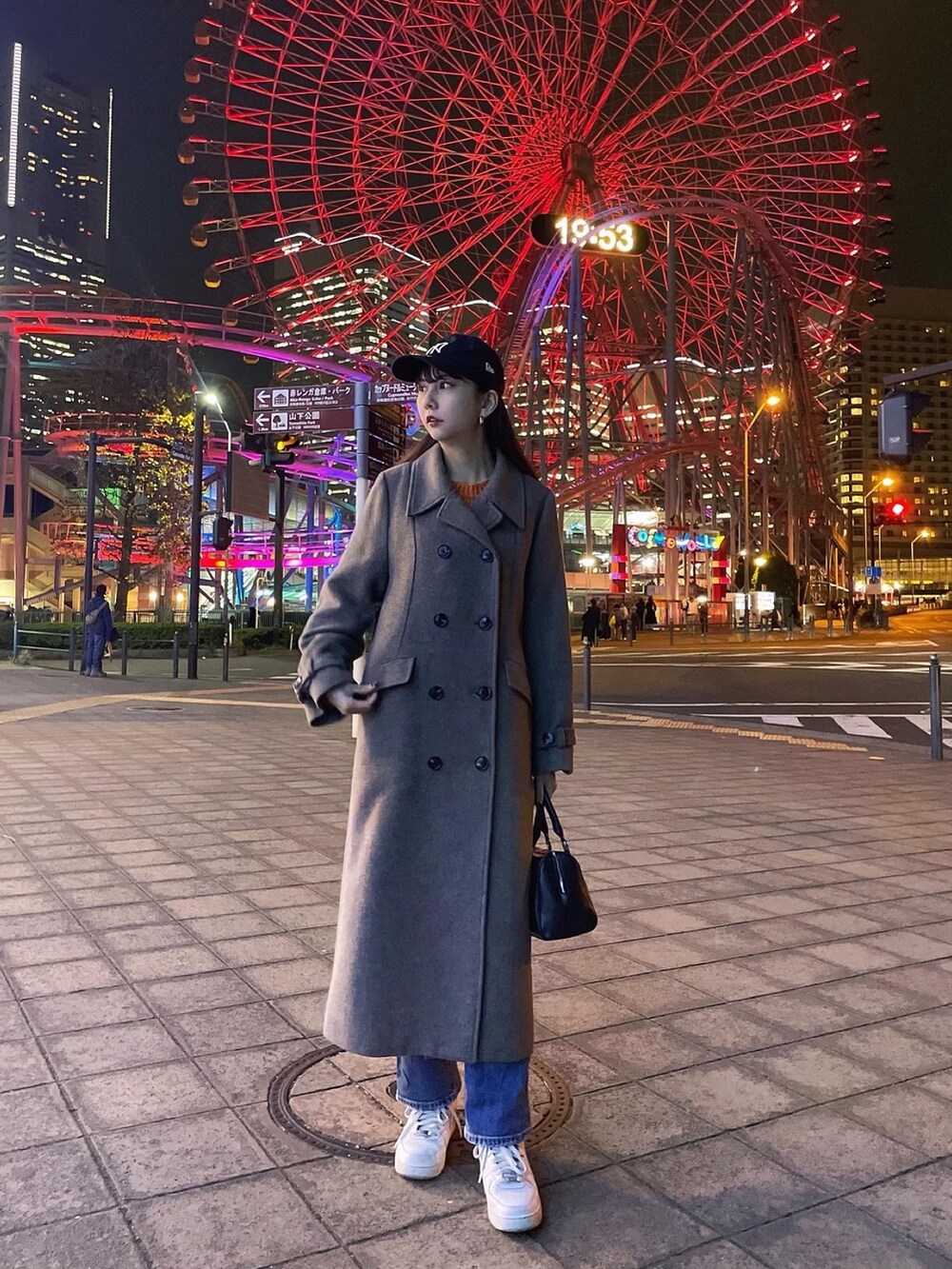 ブラウン系のチェスターコートを着用したレディースの冬コーディネートの2枚目の写真