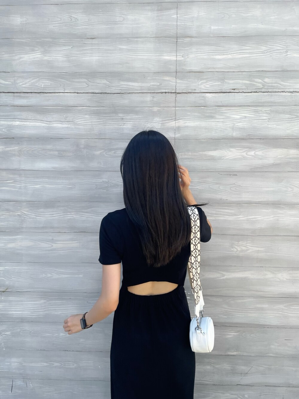 ホワイト系のショルダーバッグ、ブラック系のワンピースを着用したレディースの夏コーディネートの4枚目の写真