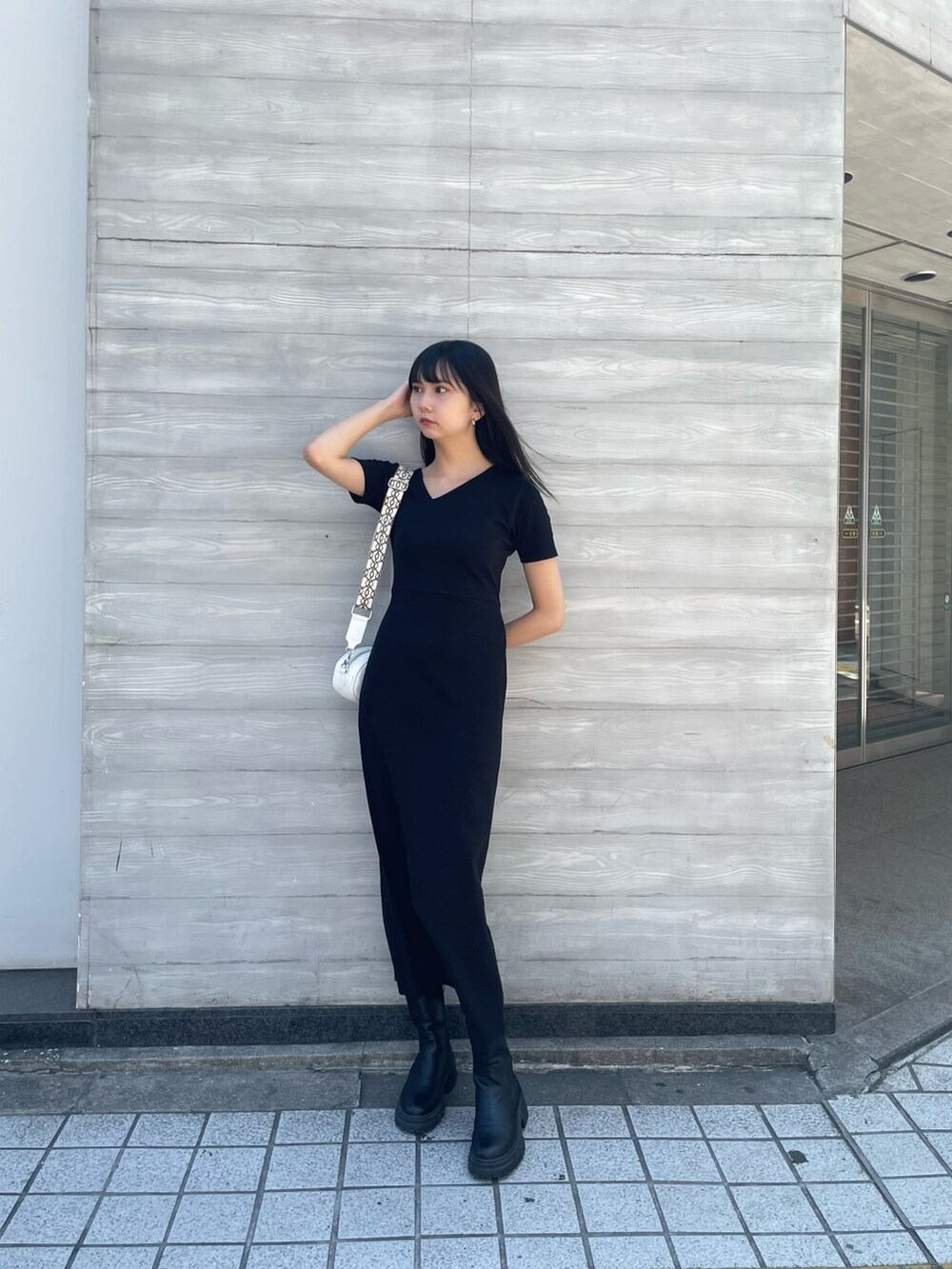 ホワイト系のショルダーバッグ、ブラック系のワンピースを着用したレディースの夏コーディネートの3枚目の写真