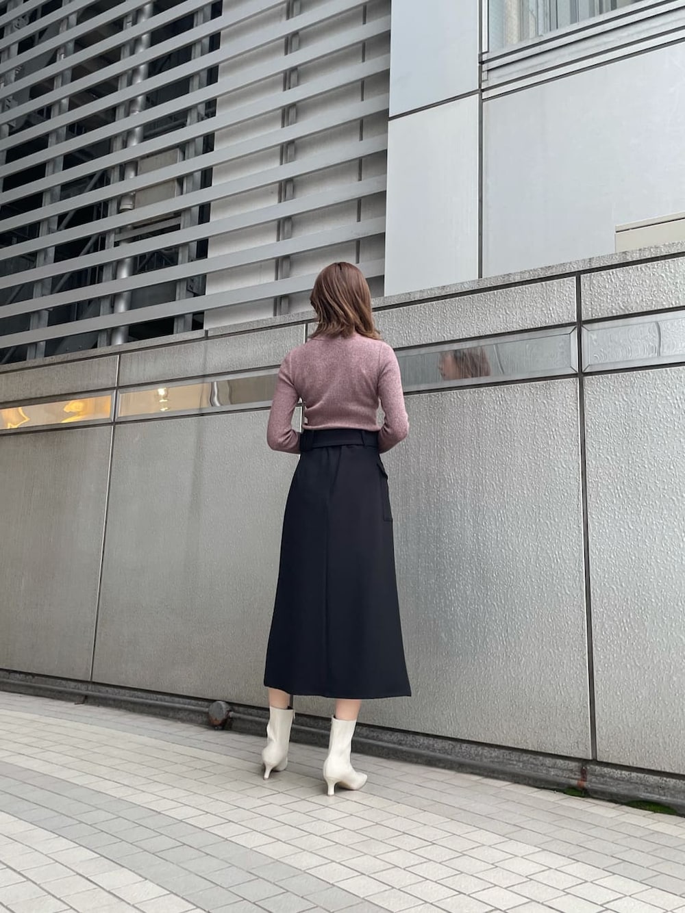 ブラック系のスカート、ブラック系のブルゾン、ホワイト系のブーツを着用したレディースの秋コーディネートの4枚目の写真