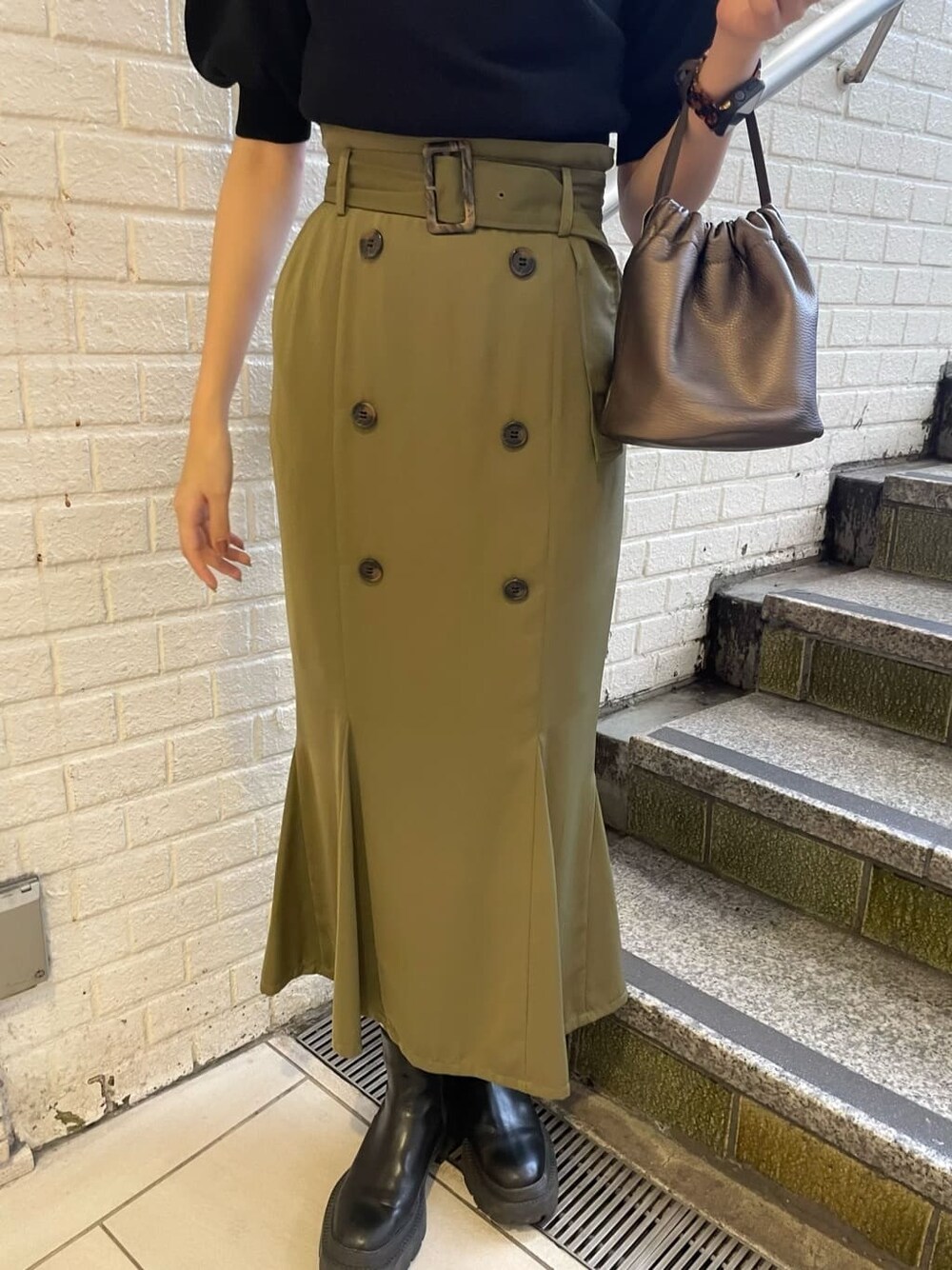 ベージュ系のスカート、ブラック系のニット/セーターを着用したレディースの夏コーディネートの7枚目の写真