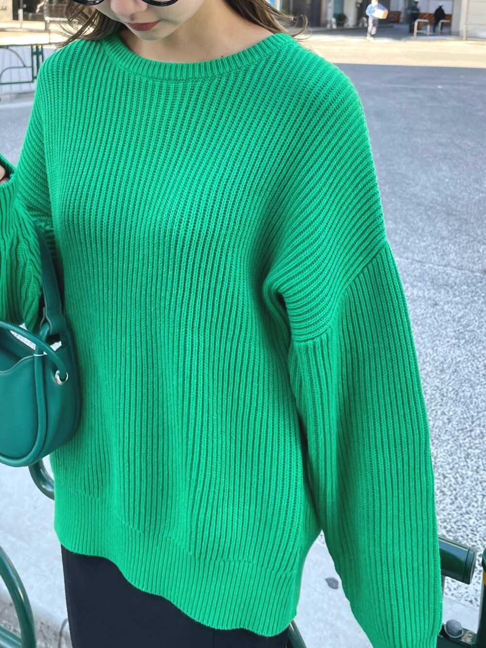 グリーン系のニット/セーター、グリーン系のハンドバッグ、ブラック系のスカートを着用したレディースの冬コーディネートの6枚目の写真