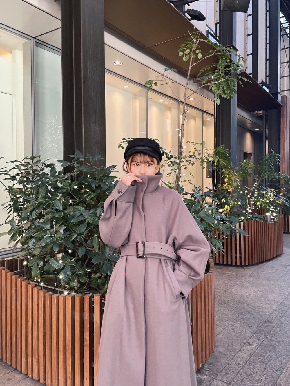 ブラウン系のステンカラーコートを着用したレディースの冬コーディネートの5枚目の写真