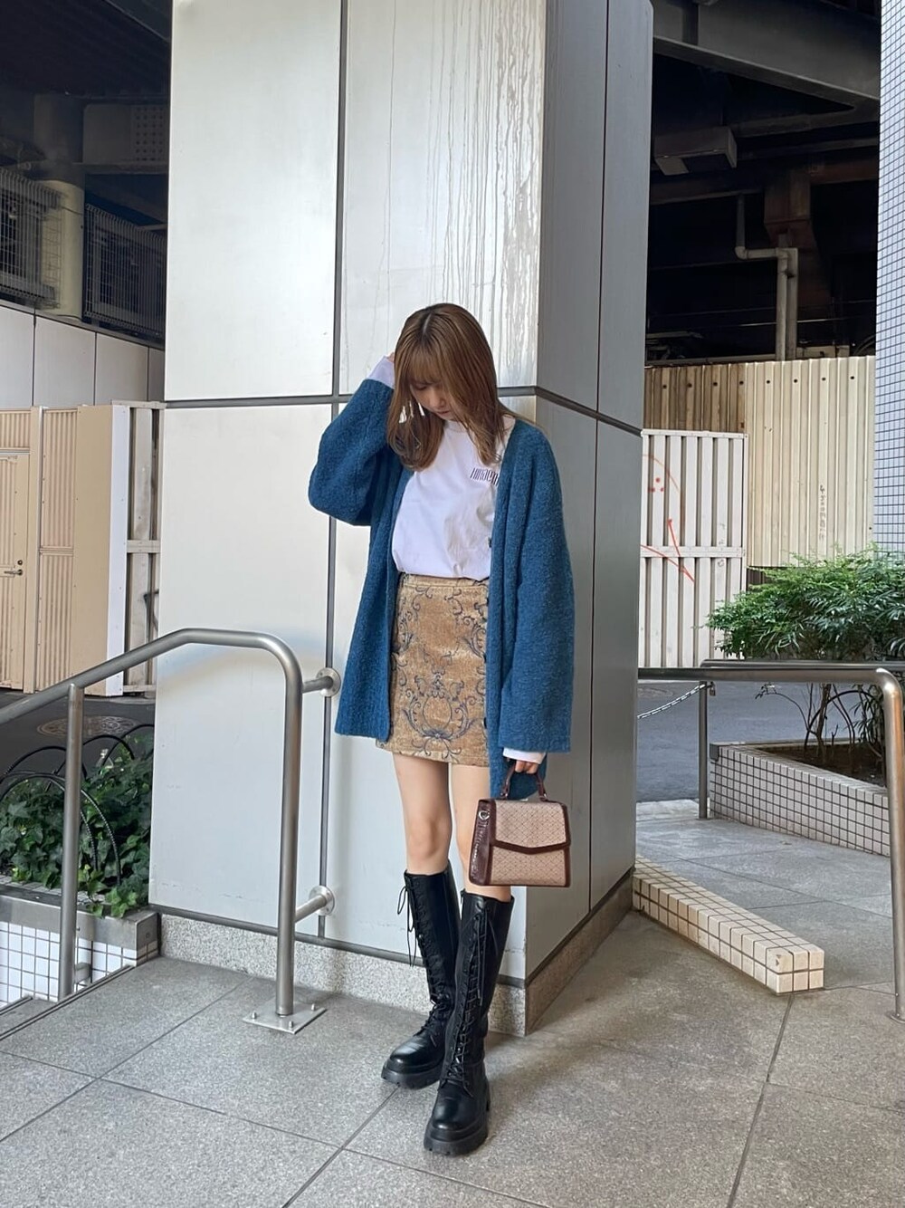 ホワイト系のTシャツ/カットソー、ブラウン系のスカート、ブルー系のカーディガン/ボレロを着用したレディースの秋コーディネートの2枚目の写真