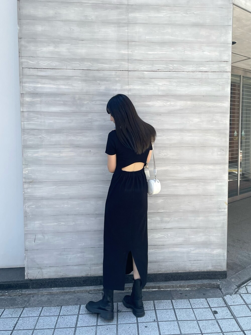 ホワイト系のショルダーバッグ、ブラック系のワンピースを着用したレディースの夏コーディネートの2枚目の写真