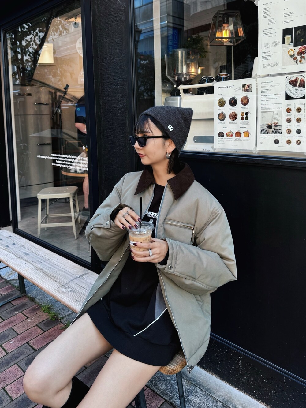 グリーン系のブルゾン、ブラック系のブーツ、ブラック系のスウェットを着用したレディースの秋コーディネートの4枚目の写真