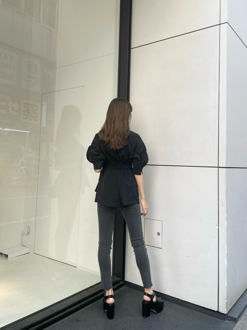 ブラック系のシャツ/ブラウス、グレー系のデニムパンツ、ブラック系のサンダルを着用したレディースの春コーディネートの2枚目の写真