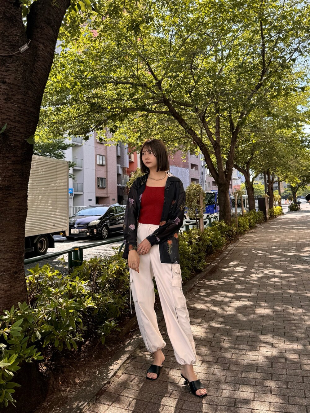 ブラック系のシャツ/ブラウス、レッド系のニット/セーター、ホワイト系のカーゴパンツを着用したレディースの夏コーディネートの2枚目の写真