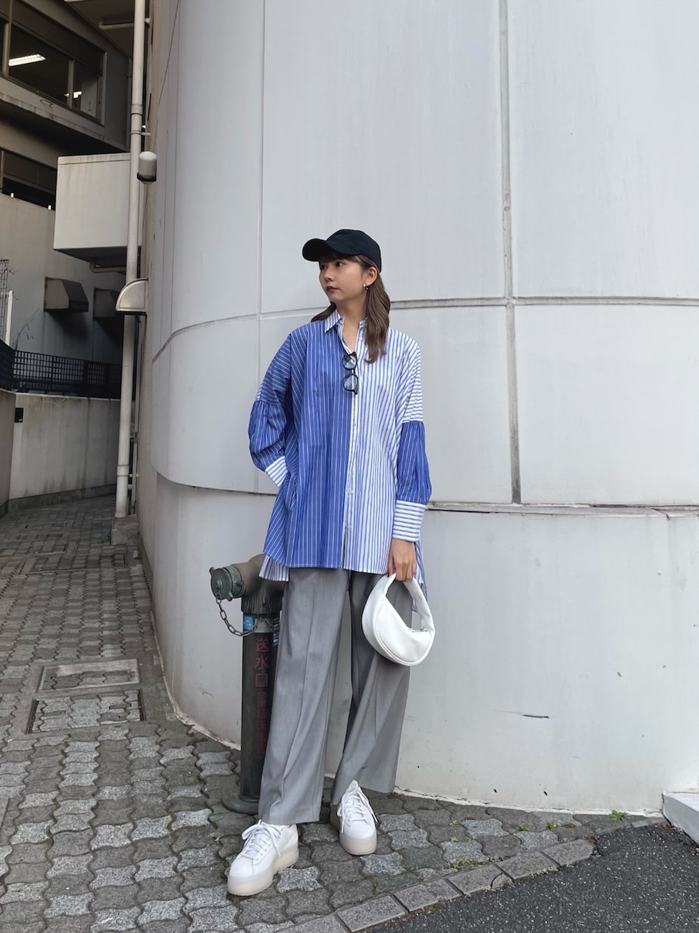 ブルー系のシャツ/ブラウス、ホワイト系のハンドバッグ、グレー系のスラックスを着用したレディースの冬コーディネートの3枚目の写真