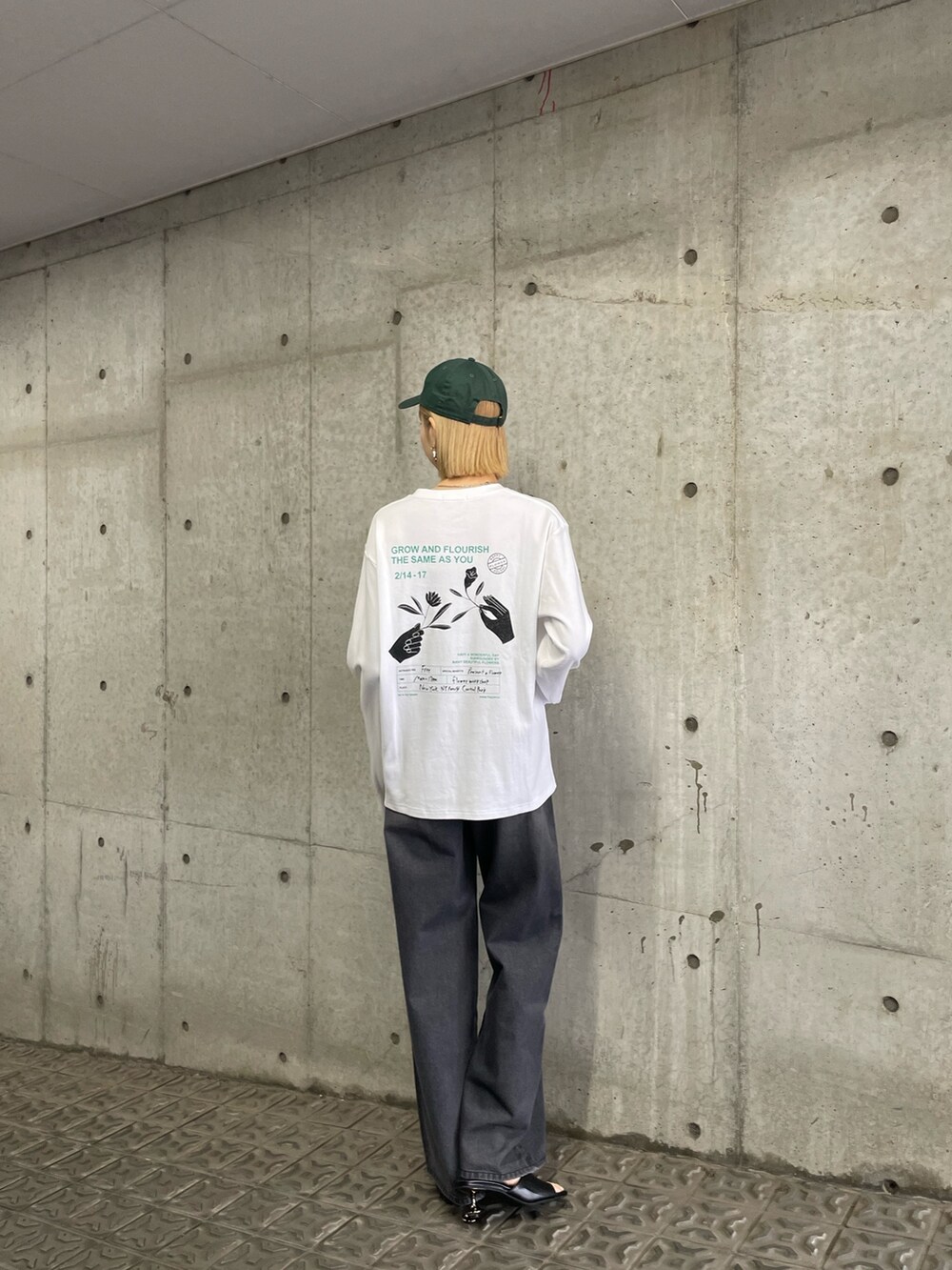 ブラック系のサンダル、ブラック系のデニムパンツ、ホワイト系のTシャツ/カットソーを着用したレディースの冬コーディネートの2枚目の写真